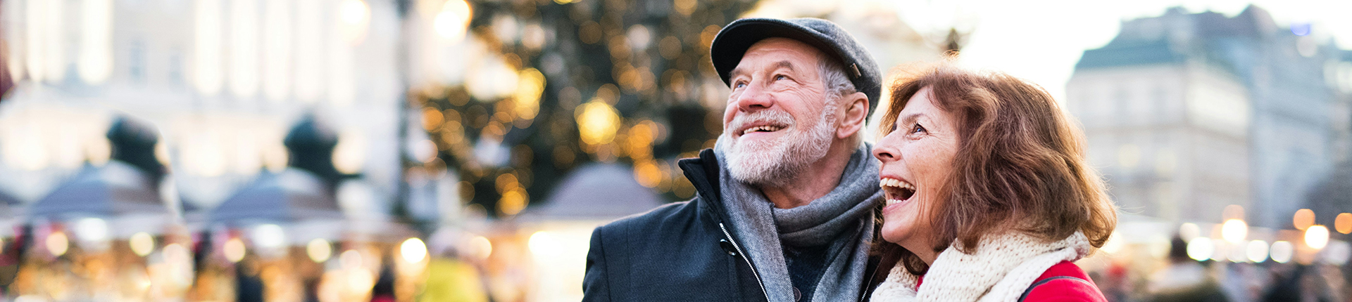 Happy couple visiting an outdoor Christmas Market in Europe during winter