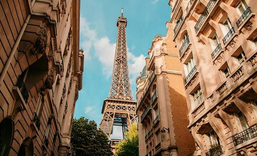 Eiffel Tower framed by buildings in Paris, France during daytime.