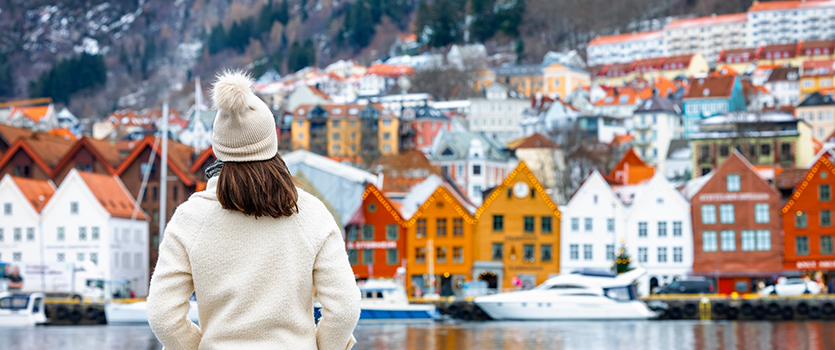 Woman looking at colorful Bryggen district in Bergen, Norway on a cold winter day